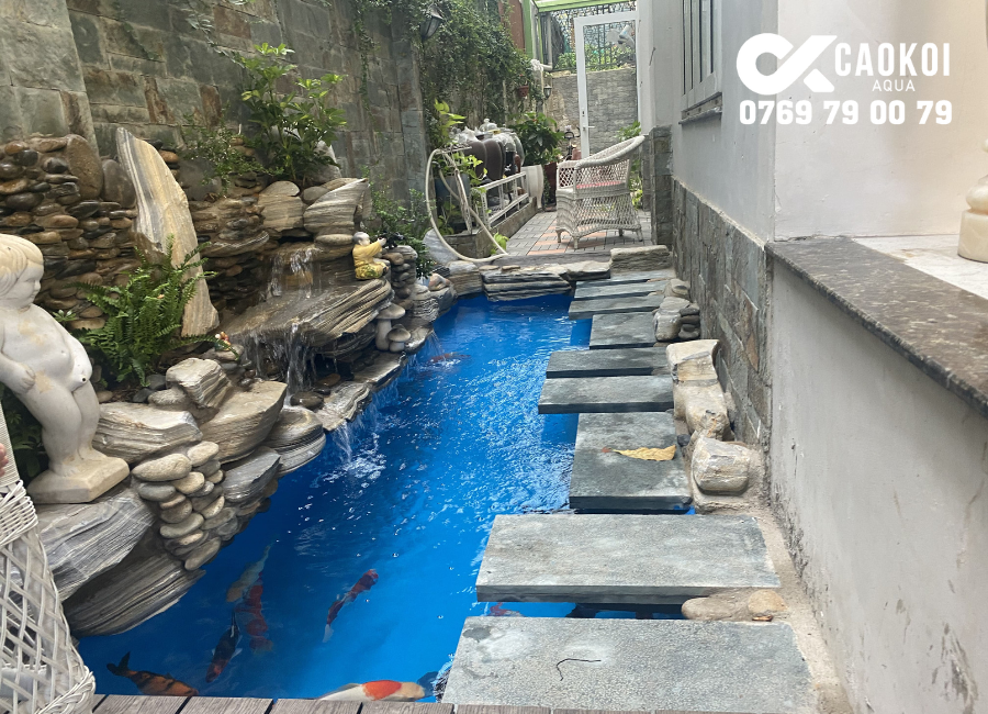 Dịch vụ thiết kế và thi công hồ cá koi từ A-Z tại TPHCM Công trình hồ cá Koi tại quận 7, được trang trí cùng tiểu cảnh đá và lối đi giúp gia chủ có thể dễ dàng ngắm nhìn chiếc hồ cá của mình.
